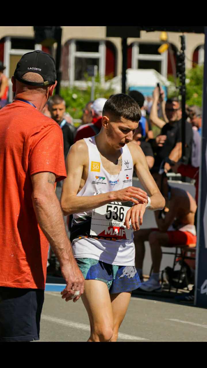 Ludovic Delpuech consulte sa montre à l'arrivée du marathon, dossard 536