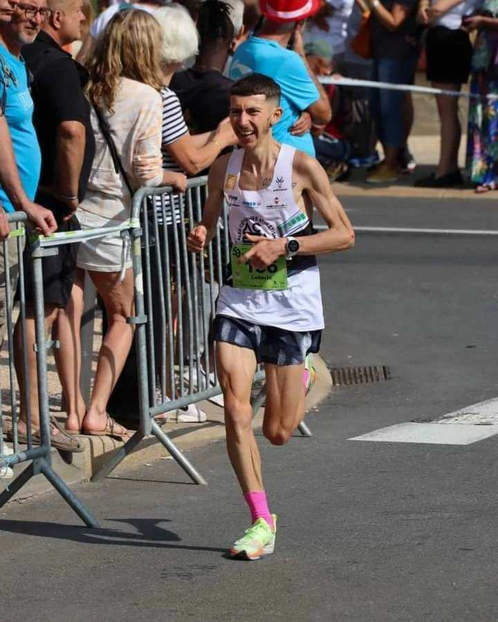 Ludovic Delpuech à l'effort en course en ville, dossard 136